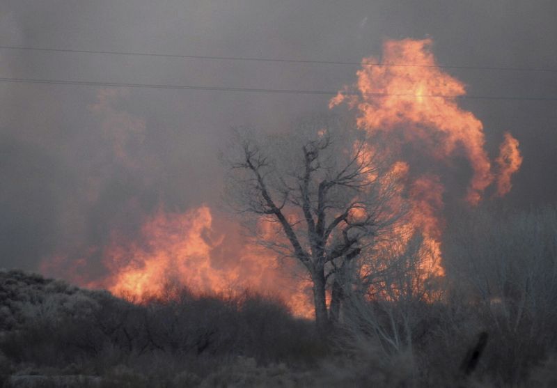 This Sunday, Feb. 18, 2018 photo taken by the Bishop California Highway Patrol and released by the Inyo County Sheriff's Office shows smoke rising from wildfires near Bishop, Calif. A wind-driven wildfire in rural central California forced mandatory evacuations and threatened hundreds of buildings Monday, including a historic railroad station, after it tripled in size overnight, officials said. (Bishop California Highway Patrol via AP)