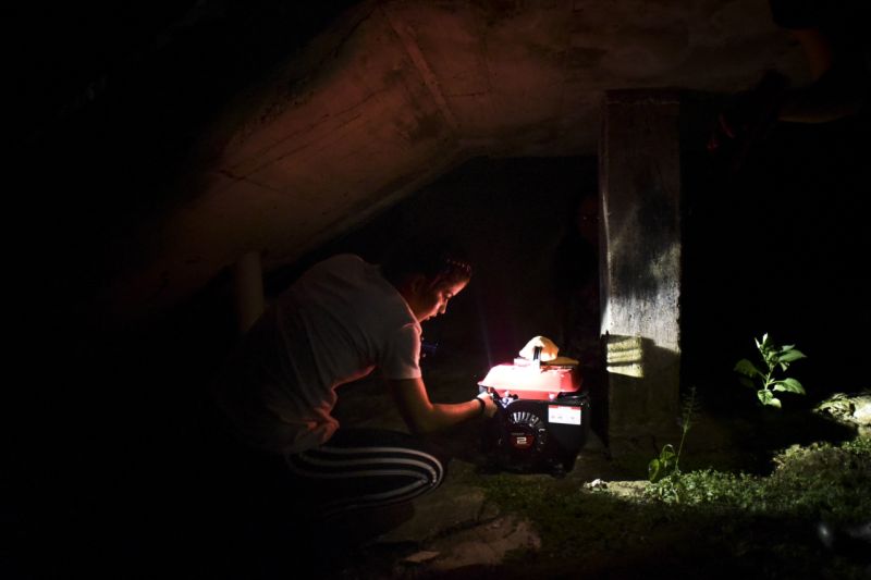 FILE - In this Dec. 21, 2017 filw photo, barrio Patron resident Karina Santiago Gonzalez works on a small power plant in Morovis, Puerto Rico. A federal control board requested on Friday, Feb. 6, 2018,  $300 million loan for Puerto Rico's power company after a federal judge rejected a previous $1 billion loan request despite warnings the U.S. territory would have to start rationing electricity. Some 400,000 customers remain in the dark five months after Hurricane Maria. (AP Photo/Carlos Giusti, File)