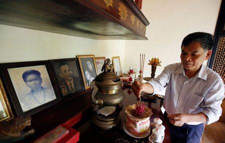 Colonel Vo Cao Tri places incenses in front of his mother's portrait, who was killed by US soldiers during the My Lai massacre on March 16, 1968, at his house in Danang, Vietnam March 14, 2016.   REUTERS/Kham