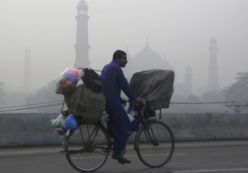 A cyclist passes by the historical Badshahi Mosque while smog envelopes the area in Lahore, Pakistan, Sunday, Nov. 5, 2017. Smog has enveloped much of Pakistan and neighboring India, causing highway accidents and respiratory problems, and forcing many residents to stay home, officials said. (AP Photo/K.M. Chaudary)