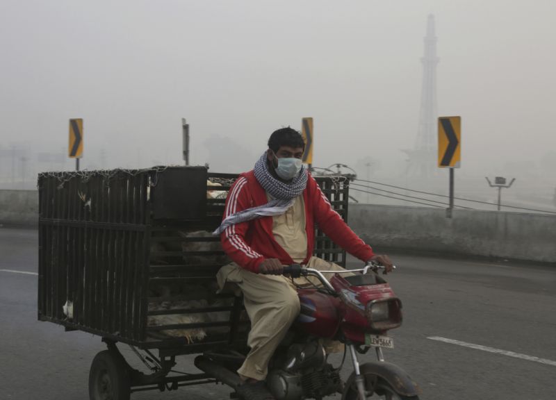 A tri-wheeler passes by Minar-e-Pakistan, the Pakistani monument, while smog envelopes the area in Lahore, Pakistan, Sunday, Nov. 5, 2017. Smog has enveloped much of Pakistan and neighboring India, causing highway accidents and respiratory problems, and forcing many residents to stay home, officials said. (AP Photo/K.M. Chaudary)