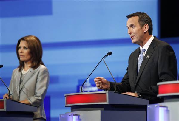 Tim Pawlenty speaks beside Michele Bachmann during the Republican presidential debate in Ames
