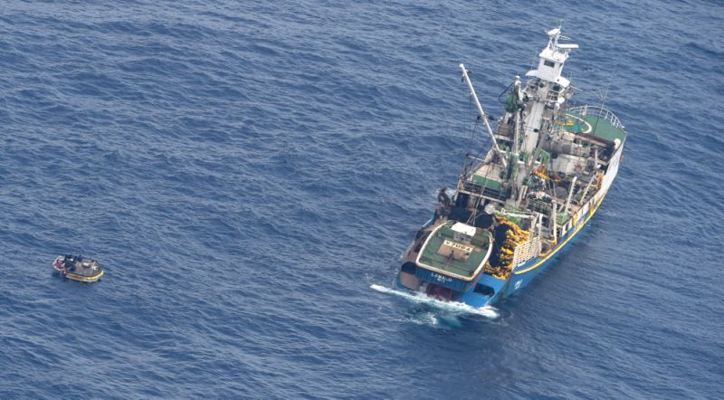 This photo released by the New Zealand Defence Force shows a wooden dinghy, left, carrying seven survivors from a missing ferry and a fishing boat in the Pacific Ocean Sunday, Jan 28, 2018. Six adults and an unconscious baby were rescued Sunday from a life raft in the Pacific Ocean after drifting for four days in the blazing sun without water. The survivors had scrambled onto the small wooden dinghy after the ferry they were aboard sank, according to authorities. (New Zealand Defence Force via AP)