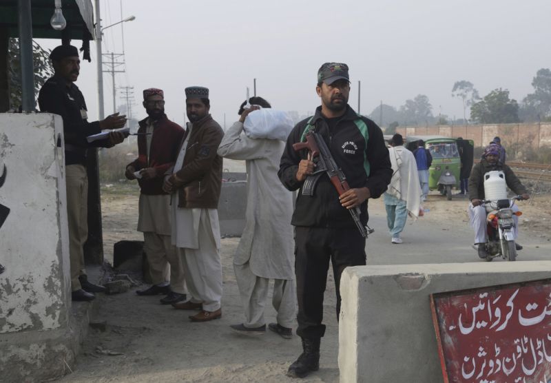 A police officer stands guard while another taking information visitors at a checkpoint of a prison, where the trial of a serial killer is being held, in Lahore, Pakistan, Saturday, Feb. 17, 2018. A public prosecutor in Pakistan says a court has sentenced a serial killer to death after finding him guilty of killing eight children, including a 7-year-old girl whose rape and murder drew nationwide condemnation. (AP Photo/K.M. Chaudary)