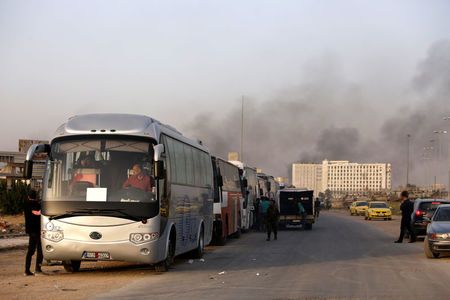 A convoy of buses that carry rebels and their families waits at Harasta highway outside Jobar, in Damascus, Syria March 26, 2018. REUTERS/Omar Sanadiki