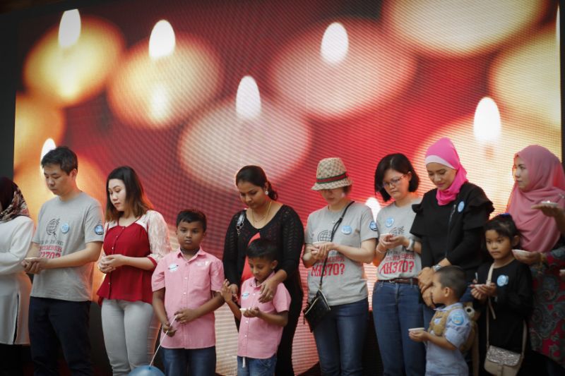 Relative of passengers on board the missing Malaysia Airlines Flight 370 have a moment of silence during the Day of Remembrance for MH370 event in Kuala Lumpur, Malaysia, Saturday, March 3, 2018. The remembrance event marked the fourth anniversary of the jet's March 8, 2014, disappearance. (AP Photo/Vincent Thian)