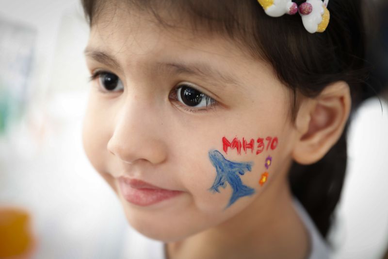 A girl has her face painted during the Day of Remembrance for MH370 event in Kuala Lumpur, Malaysia, Saturday, March 3, 2018. The remembrance event marked the fourth anniversary of the jet's March 8, 2014, disappearance. (AP Photo/Vincent Thian)