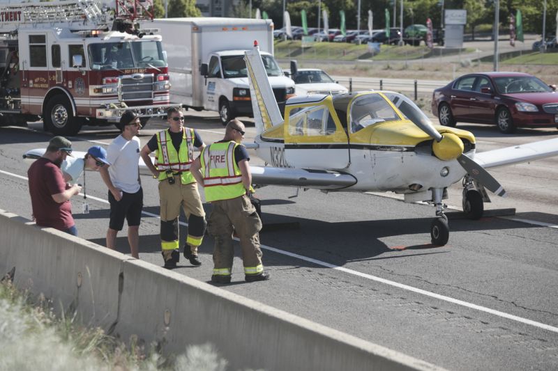 Emergency workers stand next to a plane which had to make an emergency landing on Interstate 15 in Riverdale, Utah on Saturday May, 26, 2018. (Matt Herp/Standard-Examiner via AP)