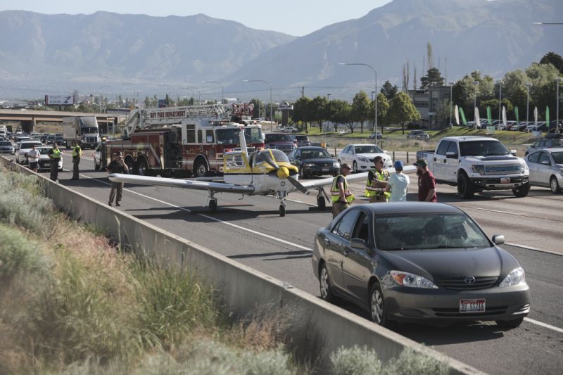 Emergency workers stand next to a plane which had to make an emergency landing on Interstate 15 in Riverdale, Utah on Saturday May, 26, 2018. (Matt Herp/Standard-Examiner via AP)