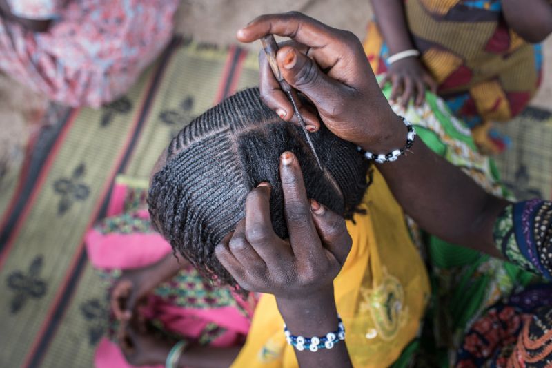 A woman braids a girl's hair at a camp for the internally displaced in northeast Nigeria, where rights groups say women and girls are at serious risk of sexual abuse and rape