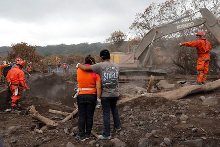 Eva Ascon, is embraced by a family member as rescue workers search for her rest of her family at the affected by the Fuego volcano at San Miguel Los Lotes in Escuintla, Guatemala  June 15, 2018. REUTERS/Carlos Jasso