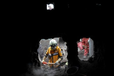 Rescue workers search for missing families at the area affected by the Fuego volcano at San Miguel Los Lotes in Escuintla, Guatemala  June 15, 2018. REUTERS/Carlos Jasso