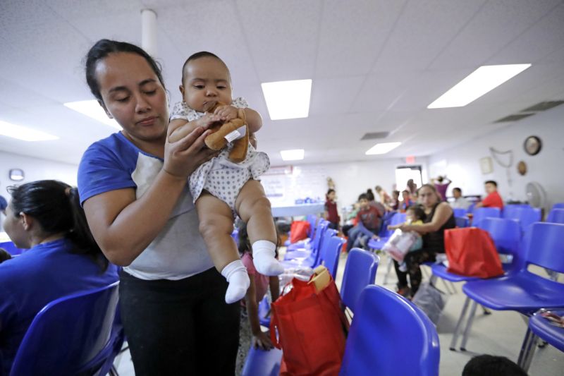 An immigrant woman from Honduras carries her baby inside the Catholic Charities of the Rio Grande Valley on Saturday, June 23, 2018, in McAllen, Texas. Families, who have been processed and released by U.S. Customs and Border Protection, wait inside the facility before continuing their journey to cities across the United States. (AP Photo/David J. Phillip)