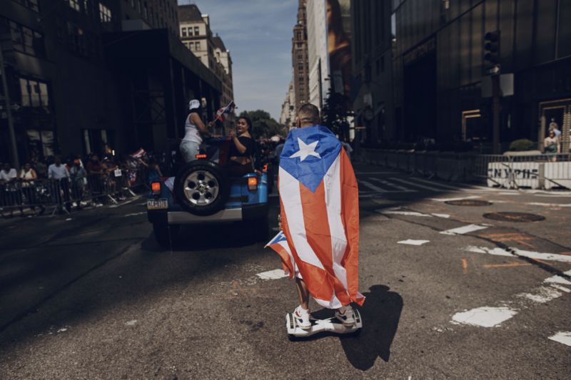 FILE - In this June 11, 2017 file photo, a man rolls on a hover-board along Fifth Avenue during the National Puerto Rican Day Parade in New York.  Amid all the fun and celebration planned for this years parade on Sunday, June 10, 2018, organizers and participants want to keep a spotlight on something serious. They want people to remember that months after Hurricane Maria roared through and as the next hurricane season arrives, Puerto Rico is still struggling. (AP Photo/Andres Kudacki)