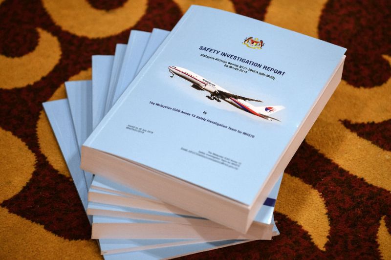 Copies of the MH370 safety investigations report are seen on the floor during a media briefing (AFP Photo/Mohd RASFAN)