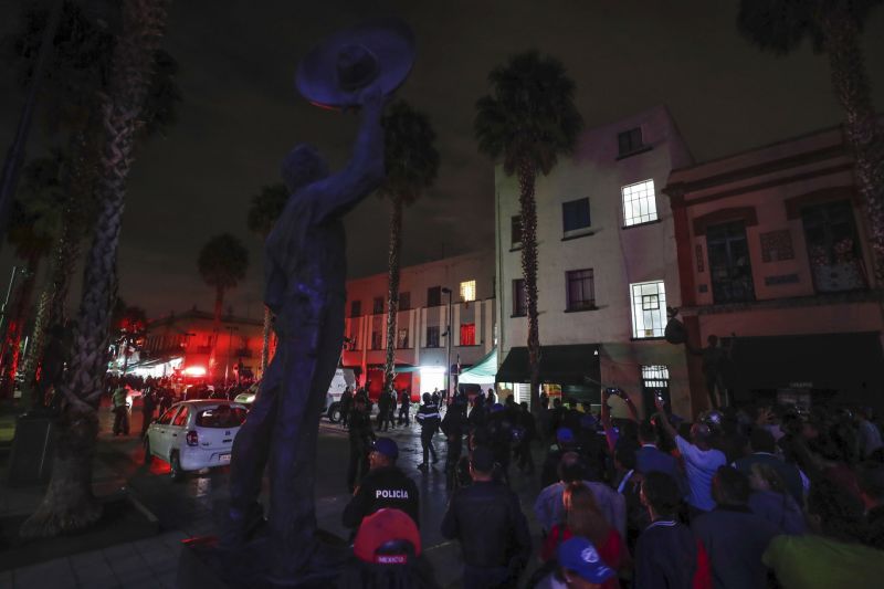 Curious onlookers gather on the perimeters of a crime scene after a shooting in Garibaldi Plaza in Mexico City, Friday, Sept. 14, 2018. Mexican authorities say at least four people have been killed and nine wounded in a shooting at the capital’s emblematic plaza. (AP Photo/Stringer)