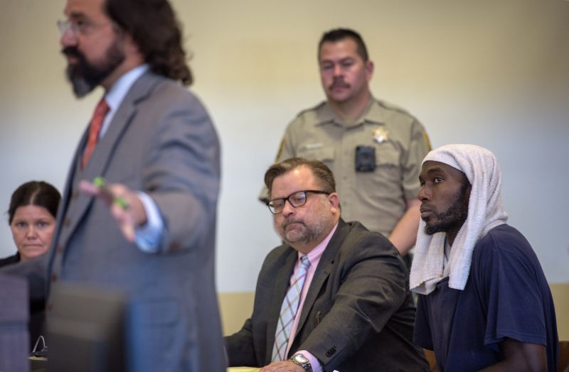 Lucas Morton, right, listens to his attorney Aleks Kostich, left, argue for his release from jail during a hearing on a motion to dismiss in the Taos County Courthouse, Wednesday, Aug. 29, 2018. Judge Emilio Chavez ordered charges against Morton and two other defendants dropped as the result of a deadline missed by prosecutors. (Eddie Moore/The Albuquerque Journal via AP, Pool)