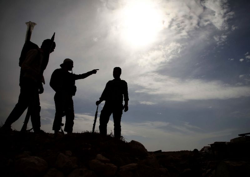 Syrian rebel-fighters with the National Liberation Front (NLF) stand on a hill overlooking regime-held areas in the northwestern countryside of Aleppo province on October 9, 2018 (AFP Photo/Aaref WATAD)
