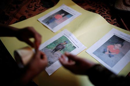 Women make an altar with pictures of Felipe Gomez Alonzo, a 8-year-old boy detained alongside his father for illegally entering the U.S., who fell ill and died in the custody of U.S. Customs and Border Protection (CBP), at the family's home in the village of Yalambojoch, Guatemala December 27, 2018. REUTERS/Luis Echeverria