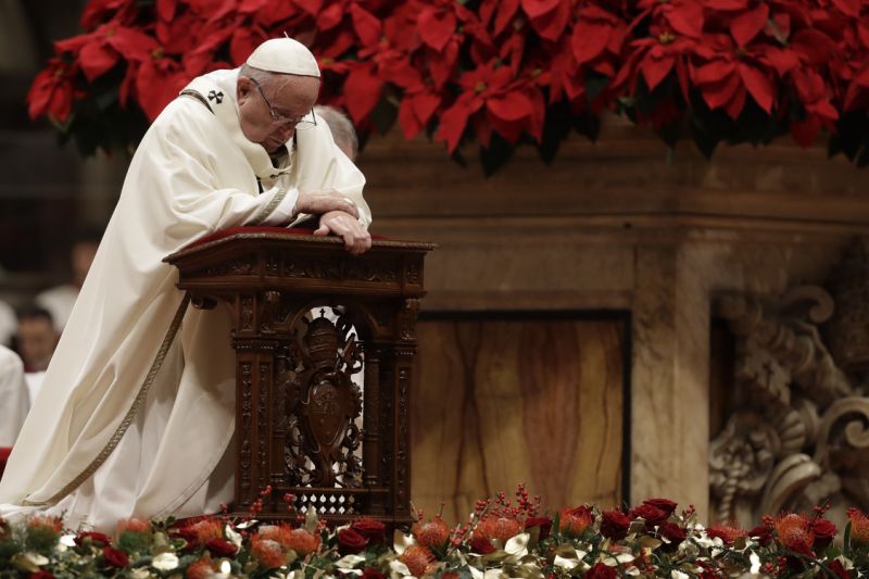 Pope Francis kneels on the altar as he celebrates the Christmas Eve Mass in St. Peter's Basilica at the Vatican, Monday, Dec. 24, 2018. (AP Photo/Alessandra Tarantino)