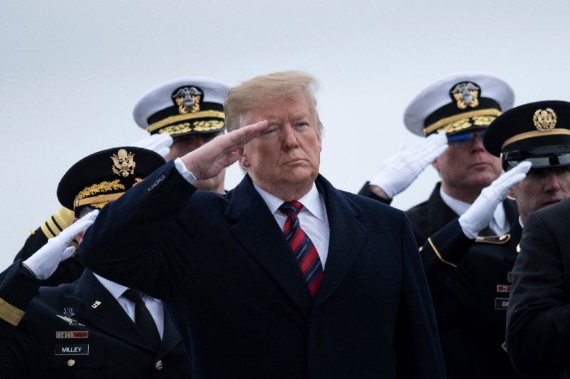US President Donald Trump and others pay their respects as the remains of Scott Wirtz, a Defense Intelligence Agency civilian and former Navy SEAL, are carried past during a ceremony at Dover Air Force Base