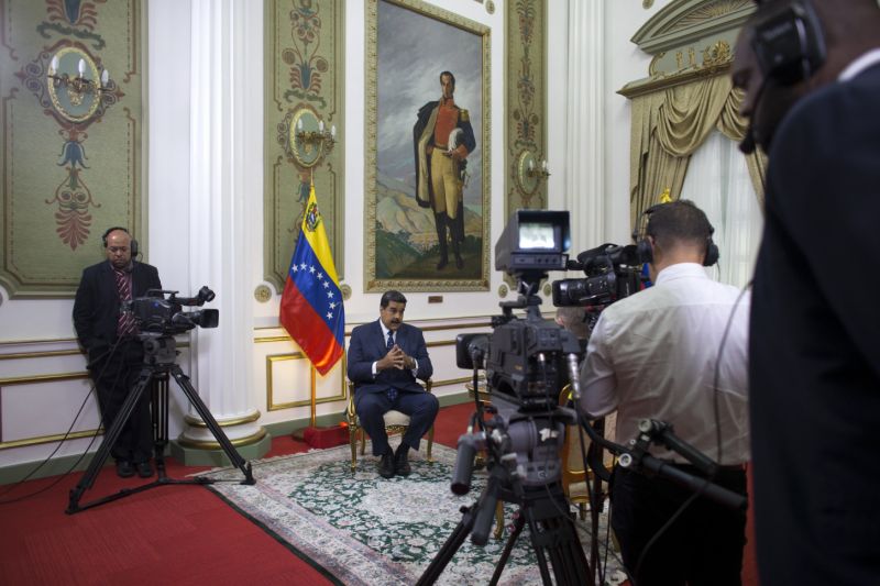 Venezuela's President Nicolas Maduro speaks during an interview with The Associated Press at Miraflores presidential palace, where a painting of independence hero Simon Bolivar hangs, in Caracas, Venezuela, Thursday, Feb. 14, 2019. Maduro is inviting a U.S. special envoy to come to Venezuela after revealing during the interview that his foreign minister recently held secret meetings with the U.S. official in New York. (AP Photo/Ariana Cubillos)