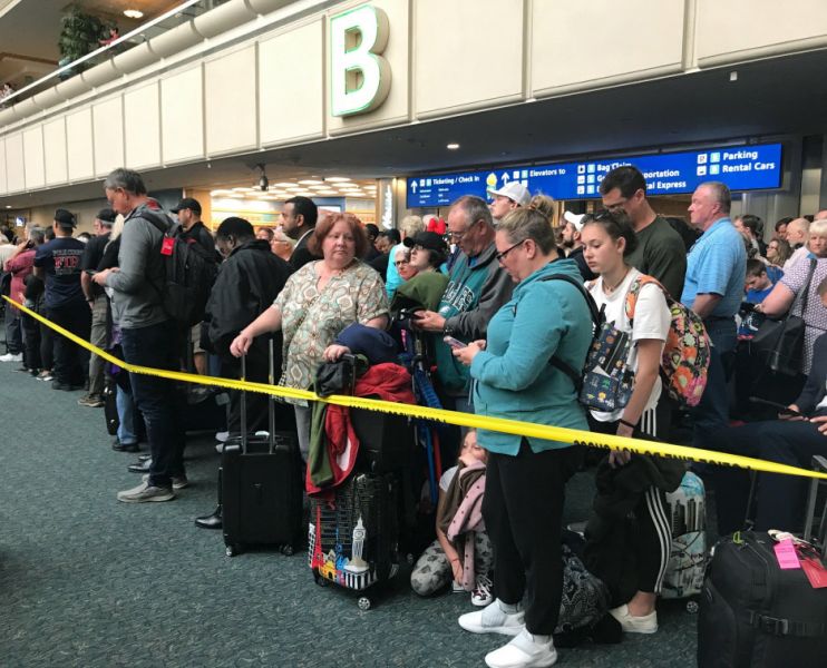 People wait to get through security at the Orlando International Airport following a security incident on Saturday, Feb. 2, 2019. Passengers on shuttles to gates at Florida's busiest airport had to be brought back for a second screening, bringing security checkpoints to a temporary standstill. A spokeswoman for Orlando International Airport told television station WKMG on Saturday that the passengers were returned in 