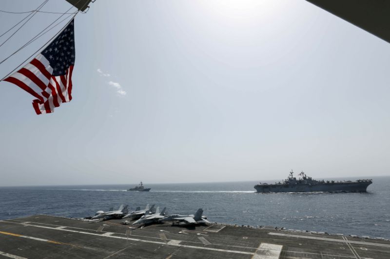 CORRECTS DATE - In this Friday, May 17, 2019, photo, released by the U.S. Navy, the amphibious assault ship USS Kearsarge, right, and the Arleigh Burke-class guided-missile destroyer USS Bainbridge, left, are seen from the Nimitz-class aircraft carrier USS Abraham Lincoln as they sail in the Arabian Sea. Commercial airliners flying over the Persian Gulf risk being targeted by 