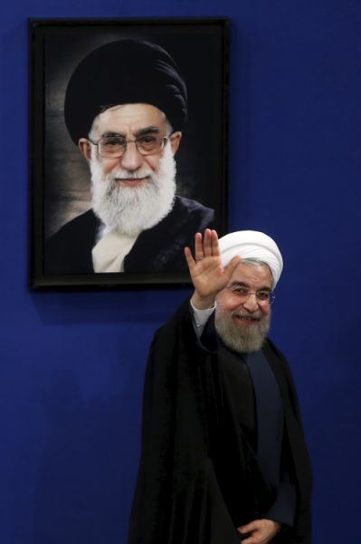 FILE - In this Aug. 29, 2015 file photo, Iran's President Hassan Rouhani waves to reporters at the conclusion of a press conference in Tehran, Iran. Iran threatened Wednesday, May 8, 2019, to resume higher enrichment of uranium in 60 days if world powers fail to negotiate new terms for its 2015 nuclear deal, an agreement that capped over a decade of hostility between Tehran and the West over its atomic program. A picture of Supreme Leader Ayatollah Ali Khamenei hangs on the wall behind Rouhani. (AP Photo/Ebrahim Noroozi, File)