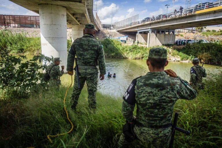 Mexican National Guard watch as Central American migrants try to cross the Rio Grande river from Matamoros, Mexico into the United States in July (AFP Photo/CARLOS OGAZ)