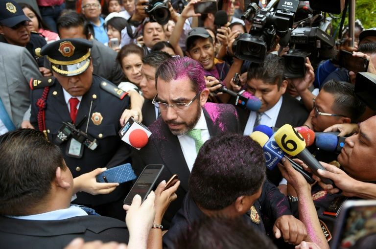 Protesters covered Mexico City's security minister, Jesus Orta, with pink glitter at a demonstration demanding justice for two teenage girls who say they were raped by police