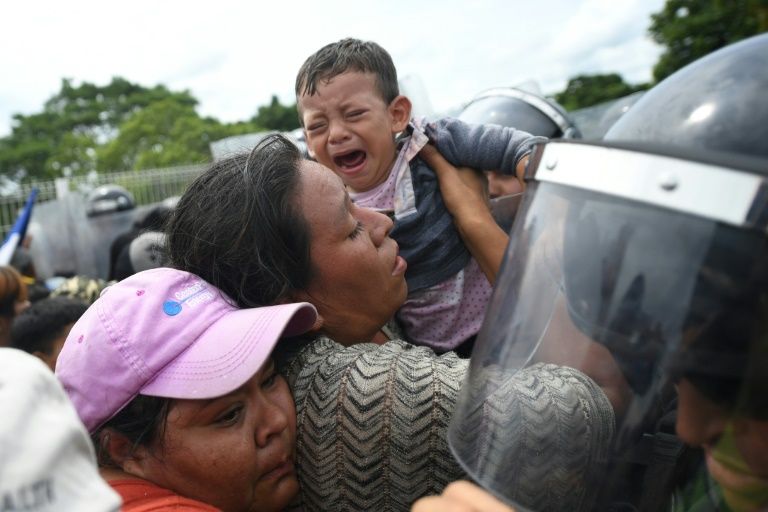 Honduran migrants struggle to cross one of the gates of the Guatemala-Mexico international border bridge in Ciudad Hidalgo, Chiapas state, Mexico, on October 19, 2018 (AFP Photo/Pedro Pardo )