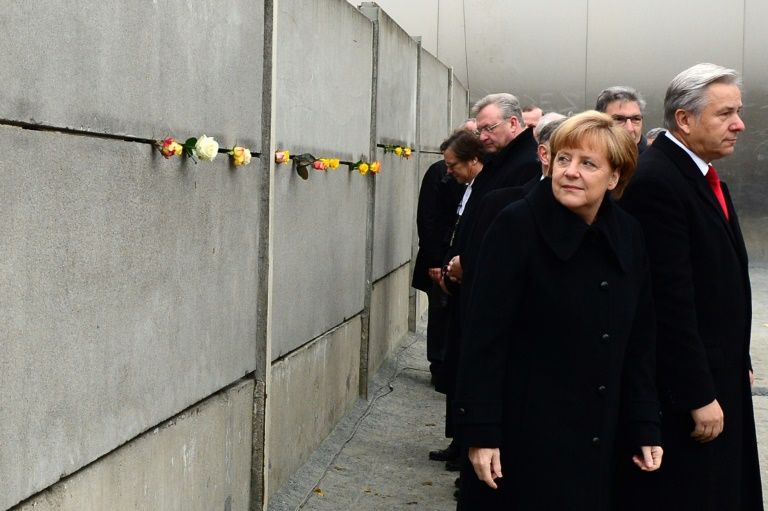 German Chancellor Angela Merkel leaving a tribute in a preserved segment of the Berlin Wall in 2014