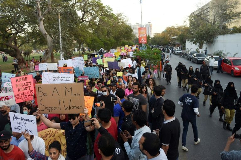 Women marched in a number of cities in Pakistan, escorted here in Karachi by armed policewomen (AFP Photo/Rizwan TABASSUM)