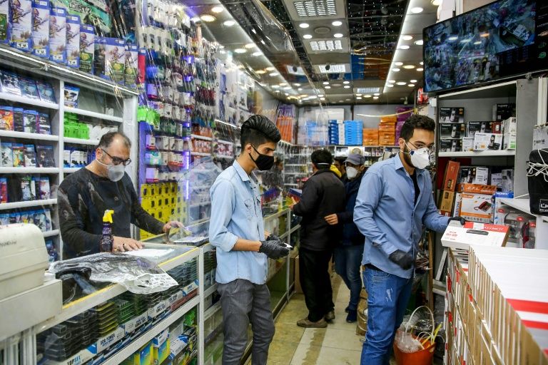 Iranian men, wearing personal protective equipment, in an electronics shop in Mashhad (AFP Photo/-)