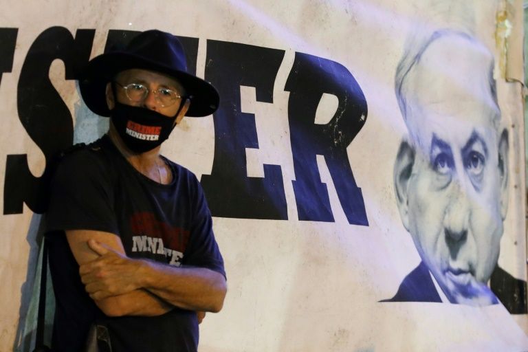 An Israeli protester, wearing a protective mask bearing the slogan "Crime Minister", takes part in a demonstration against Netanyahu in Tel Aviv earlier this month (AFP Photo/JACK GUEZ)