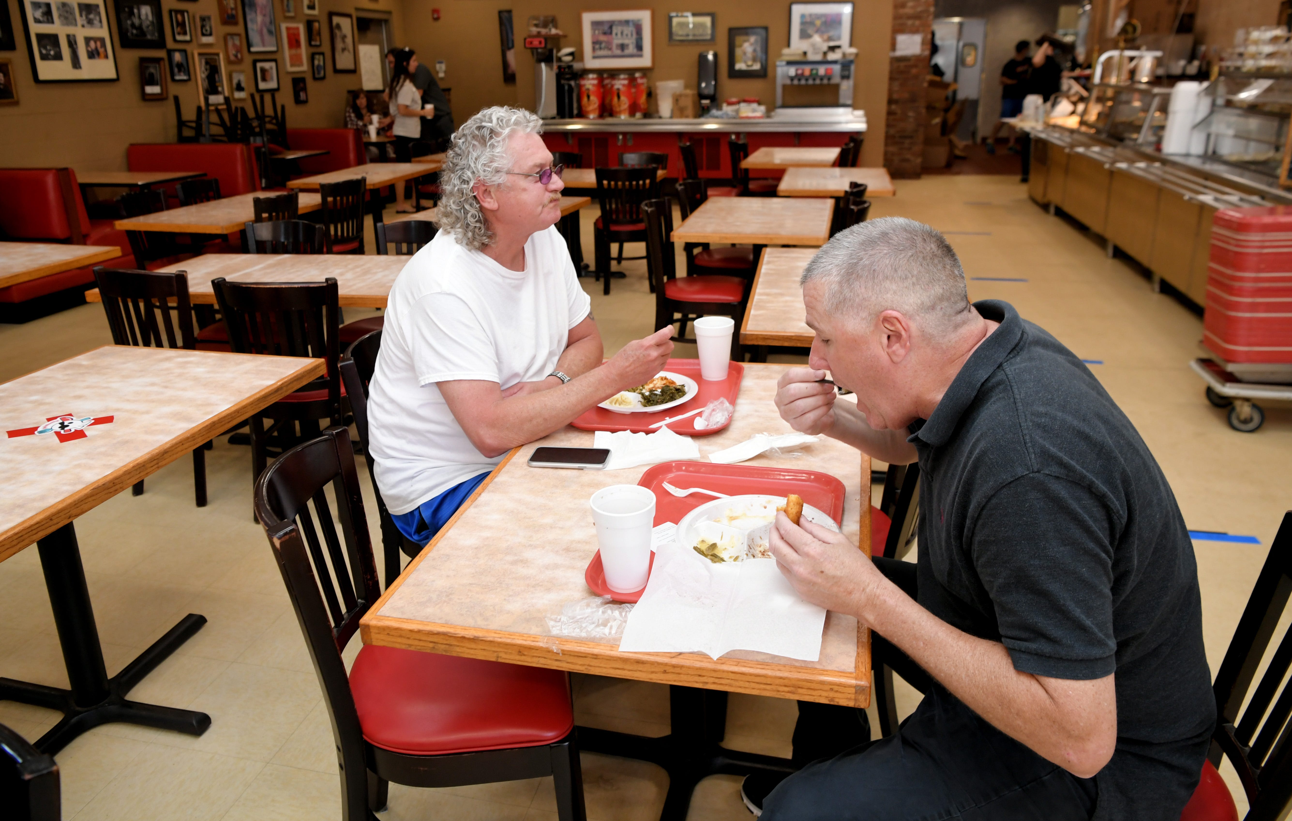Joey Elkins and Ricky Anderson eat lunch at Arnold’s Country Kitchen Monday, May 11, 2020, in Nashville, Tenn. Nonessential businesses have been closed for seven weeks due to the coronavirus pandemic, including no in-person dining at restaurants. Mayor John Cooper is allowing them to open in the first phase of lifting coronavirus restrictions.