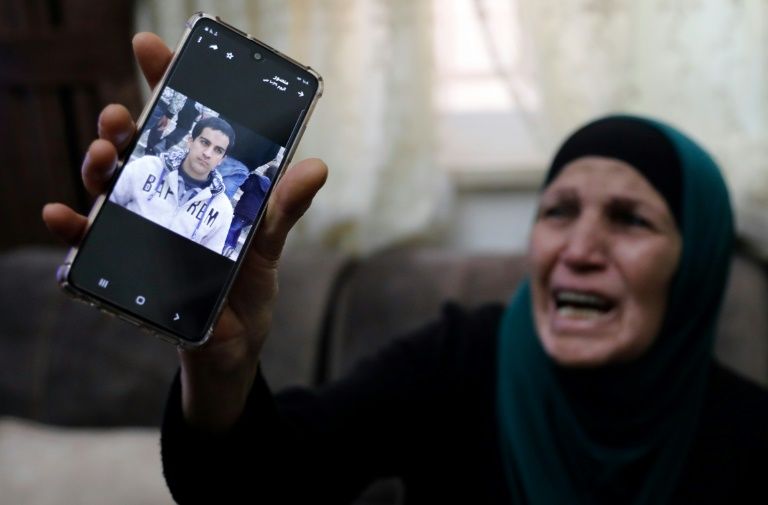 The mother of the Palestinian man shot dead by Israeli police shows his picture at her home in annexed east Jerusalem (AFP Photo/Ahmad GHARABLI)