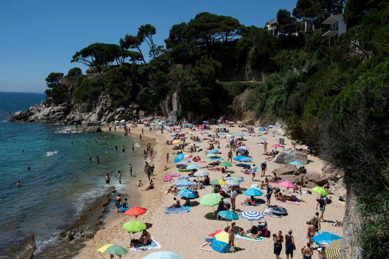 People enjoy a day out at the beach in Platja D'Aro near Girona -- Spaniards endured one of the world's toughest lockdowns for three months from March 2020 (AFP Photo/Josep LAGO)