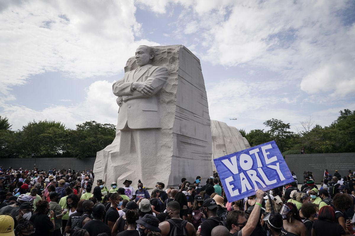 One demonstrator in the crowd in front of the MLK Memorial holds a sign urging people to “Vote early.”