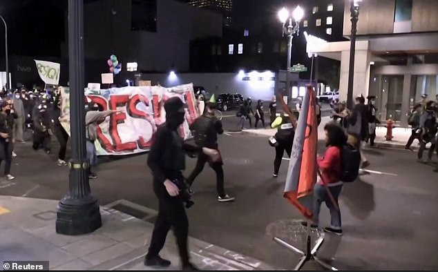 Some of the demonstrators carried party balloons and wore birthday hats, while others carried large signs telling the mayor to 'resign'