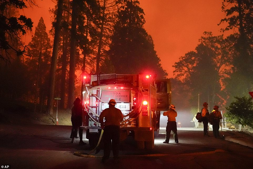 Firefighters stage near a Southern California Edison power station to protect it from the advancing Creek Fire on Sunday