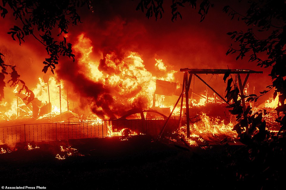 Flames consume a home and car as the Bear Fire burns through the Berry Creek area of Butte County, California, on Wednesday