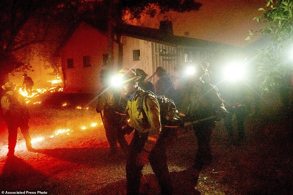 A hand crew works to save a home as the Bear Fire burns through the Berry Creek area of Butte County, California, on Wednesday