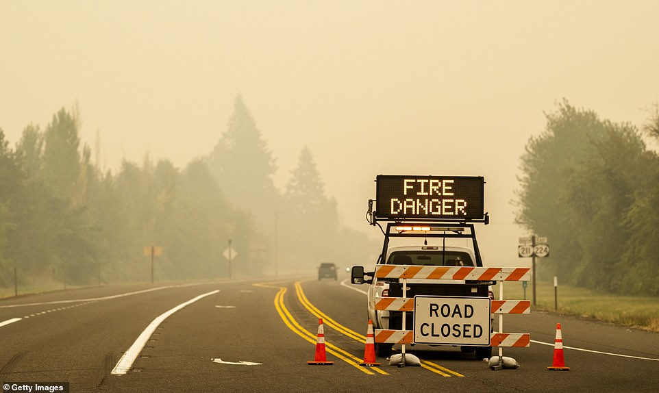 A sign warning of impending fire danger is posted on a roadway in Estacada, Oregon. Multiple wildfires grew by hundreds of thousands of acres Thursday, prompting large-scale evacuations throughout the state