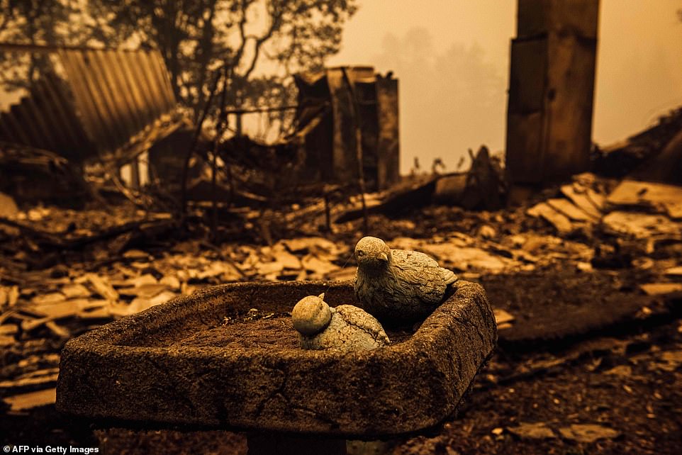 A bird bath is seen in front of the charred remains of a home after the passage of the Santiam Fire in Gates, Oregon, on Thursday