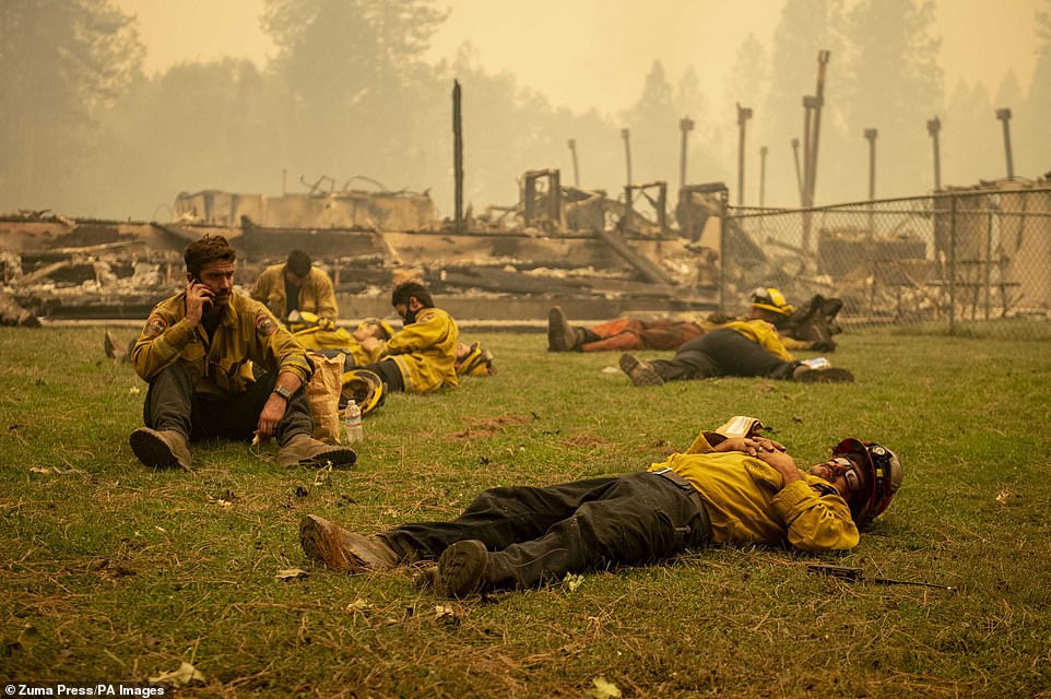 More than 14,000 firefighters are battling 28 fires across California, according to the Department of Fires and Forestry Protection. An exhausted Cal Fire crew were seen taking a break in the grass next to Berry Creek Elementary School, which was destroyed overnight during the Bear Fire on Wednesday