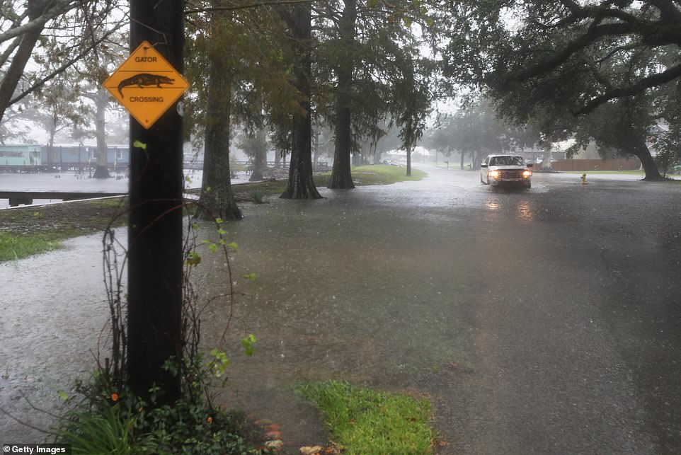 A truck drives through flood water as rainfall and heavy winds begin hammering Lake Arthur ahead of Delta's arrival