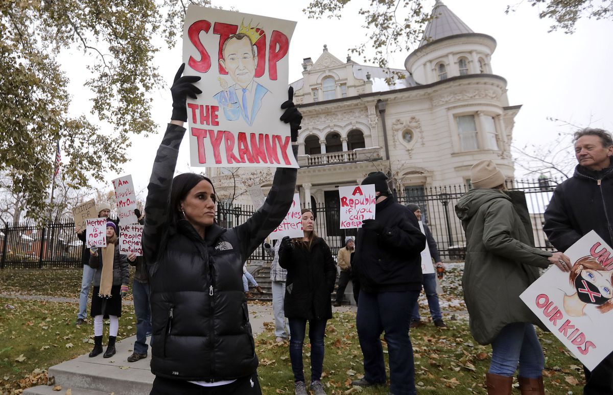 Stephanie Grant holds a “Stop the Tyranny” sign during a protest of Gov. Gary Herbert’s mask mandate and new COVID-19 restrictions outside of the Governor’s Mansion in Salt Lake City on Monday, Nov. 9, 2020.