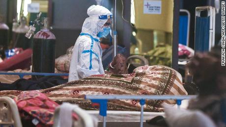 A health worker wearing a personal protective equipment suit attends a patient inside a banquet hall temporarily converted into a Covid-19 coronavirus ward in New Delhi on May 1, 2021.